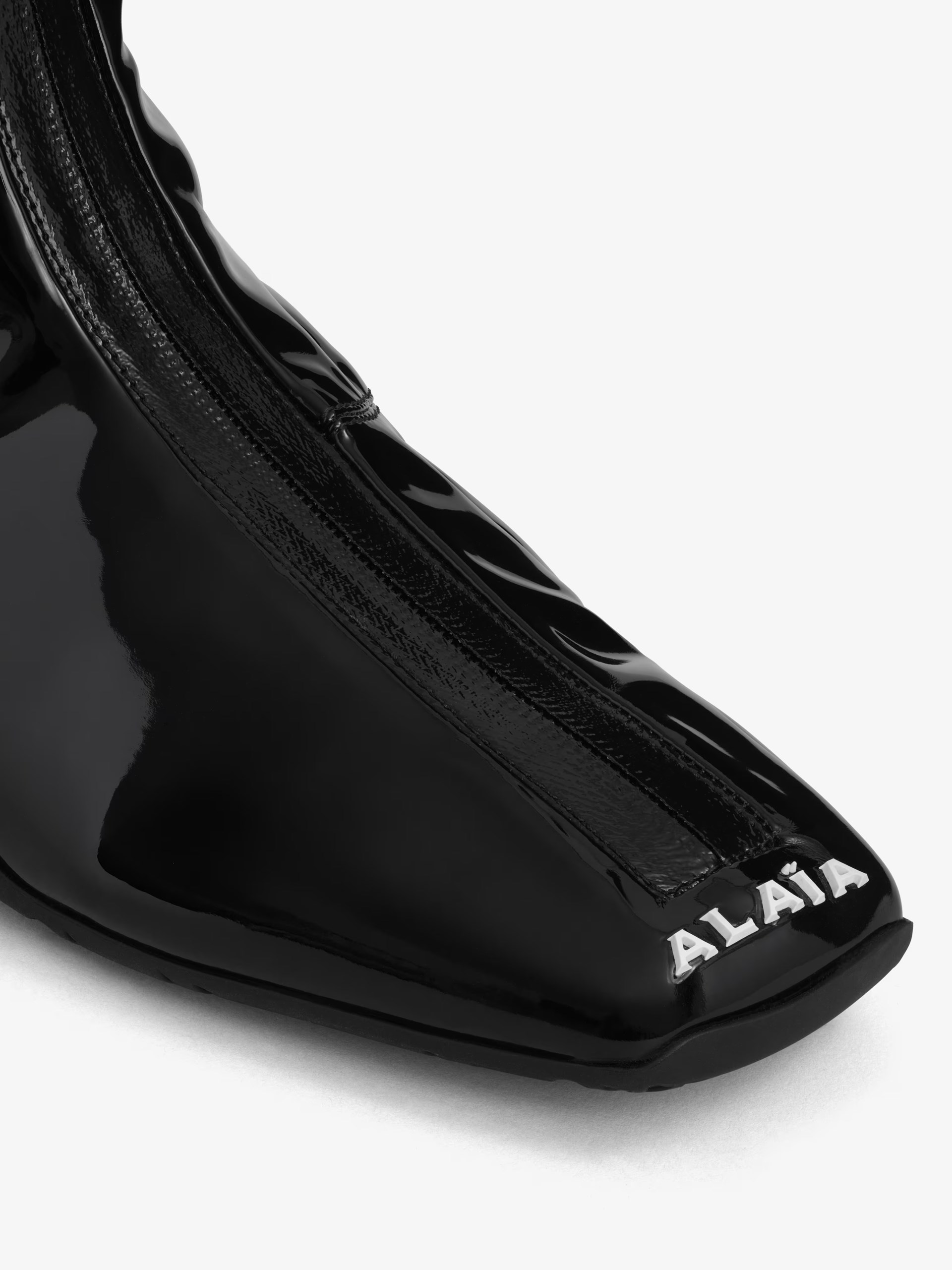 Black patent leather high-top sneakers by Alaia